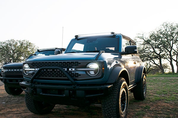 Bronco and Bronco Sport parked with lights