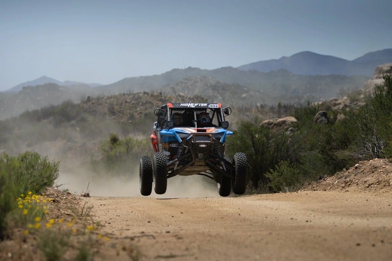 Anderson Bros team vehicle driving over desert hill at NORRA 1000