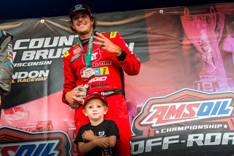 Jerrett Brooks on podium with child after placing 2nd at Crandon International Raceway